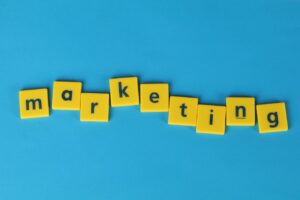 Bright yellow tiles spelling 'marketing' on a blue background, ideal for business themes.