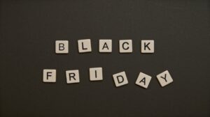 Black Friday text spelled with letter tiles on a dark flat lay background.